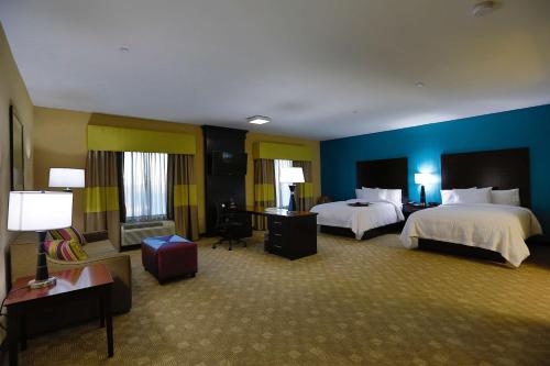 Habitación de hotel con 2 camas y paredes azules en Hampton Inn and Suites Missouri City, en Missouri City