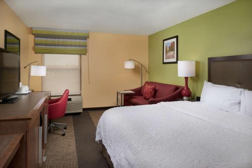 a hotel room with a bed and a desk and a chair at Hampton Inn Shelbyville in Shelbyville