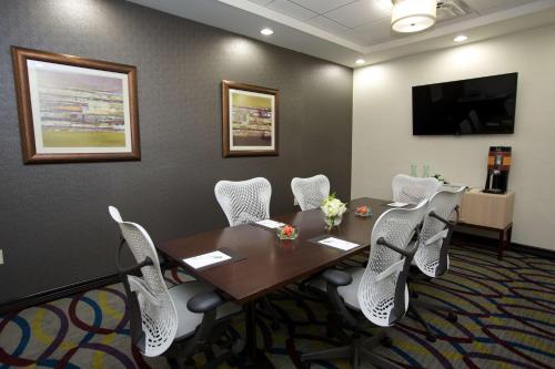 a conference room with a wooden table and white chairs at Hampton Inn and Suites Missouri City in Missouri City