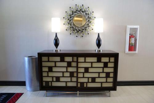 a table with two lamps and a mirror on the wall at Hampton Inn and Suites Missouri City in Missouri City