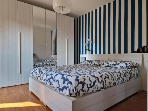 a bedroom with a bed with a blue and white comforter at Appartamento incantevole in piccola corte a Rho in Rho