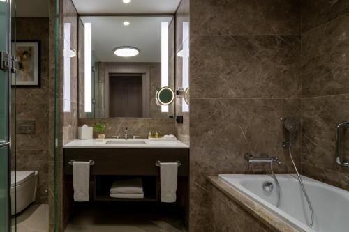a bathroom with a tub and a sink and a bath tub at Hilton Mall Of Istanbul in Istanbul