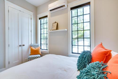 a bedroom with a bed with orange pillows and windows at Lovely Mt Pleasant Townhouse with Central Location! in Charleston