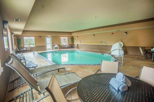 a large swimming pool with a table and chairs at Hampton Inn & Suites Palestine in Palestine