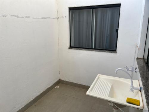a bathroom with a sink and a window at Unidades mobiliadas em condomínio in Lucas do Rio Verde