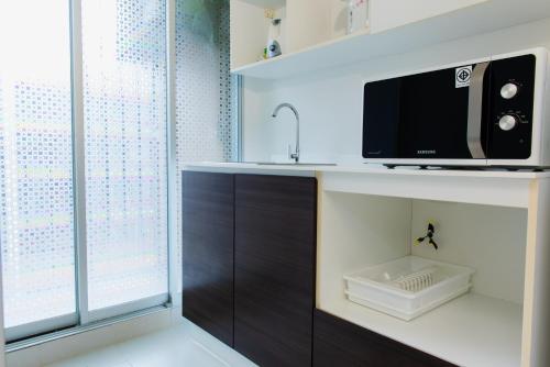 a bathroom with a sink and a microwave on a counter at Baan Koo Kiang Hua Hin คอนโดบ้านคู่เคียง หัวหิน in Hua Hin