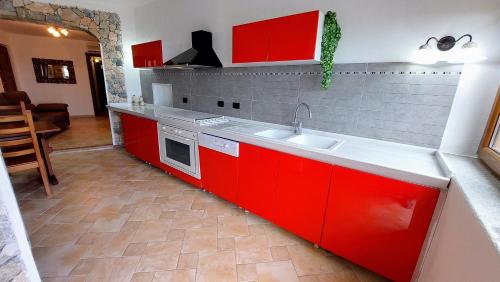cocina con armarios rojos y encimera en Vista Mare en Boissano