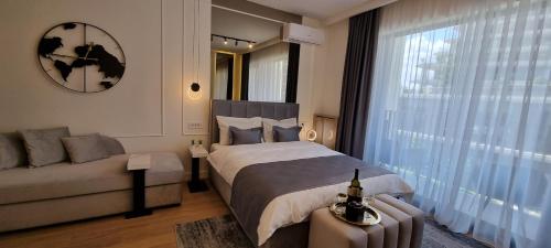 a bedroom with a bed and a couch and a window at Beograd na vodi - BW Terra Exclusive in Belgrade