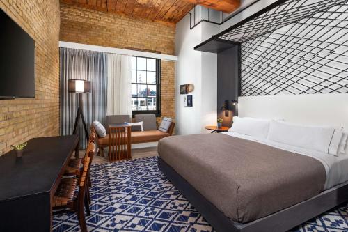 ミネアポリスにあるCanopy by Hilton Minneapolis Mill Districtのベッドルーム1室(ベッド1台、デスク、ソファ付)