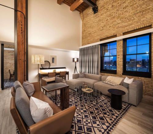 a living room with couches and a brick wall at Canopy by Hilton Minneapolis Mill District in Minneapolis
