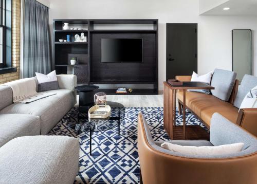 a living room with couches and a flat screen tv at Canopy by Hilton Minneapolis Mill District in Minneapolis