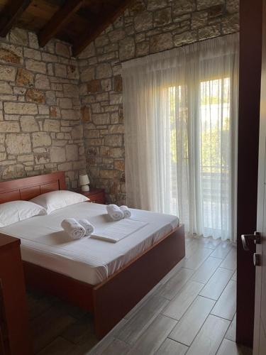 a bedroom with a bed and a stone wall at Villa Maria 2 in Gliki