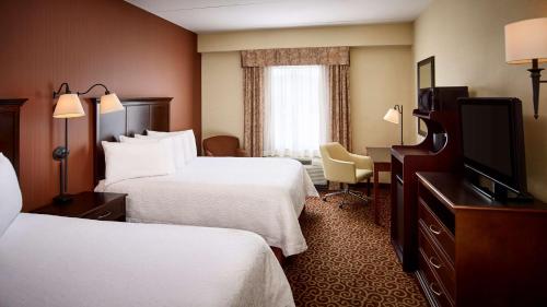 a hotel room with two beds and a flat screen tv at Hampton Inn by Hilton North Bay in North Bay