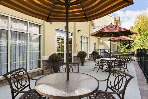 an outdoor patio with tables and chairs and umbrellas at Homewood Suites by Hilton Binghamton/Vestal in Vestal