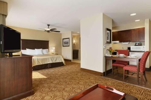 a hotel room with a bed and a desk with a tv at Homewood Suites by Hilton Binghamton/Vestal in Vestal