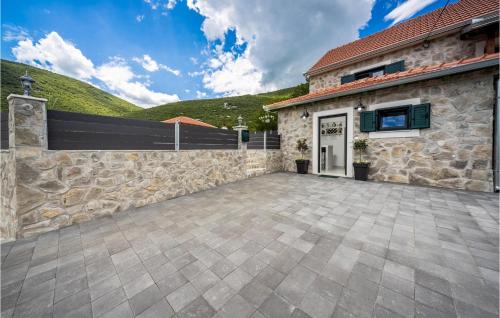 a stone house with a stone wall and a driveway at Villa Ivandvor in Sinj