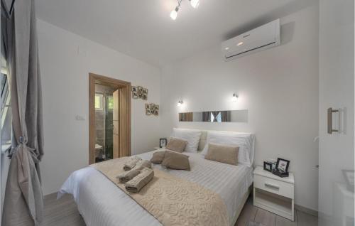 een witte slaapkamer met een bed met handdoeken erop bij Villa Ivandvor in Sinj