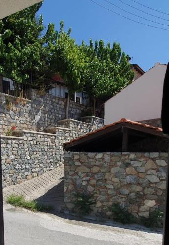 eine Steinmauer neben einem Gebäude in der Unterkunft Village Gem Peledri Studio in Pelendri