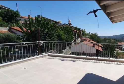 Ein Vogel fliegt über einen Balkon mit einem Zaun in der Unterkunft Village Gem Peledri Studio in Pelendri