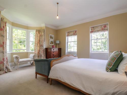 um quarto com uma cama grande e 2 janelas em Syleham House em Eye