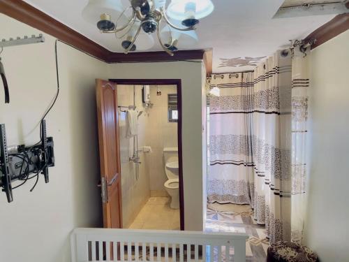 a bathroom with a toilet and a ceiling at Albert Suites & Apartments Entebbe in Entebbe