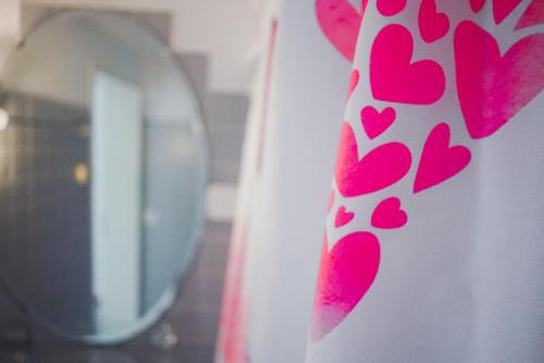 um espelho e uma parede com corações cor-de-rosa em Guest Haus on the lake em Därligen