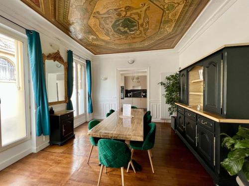 una sala da pranzo con tavolo e sedie verdi di Appartement de luxe avec fresque a Fontainebleau