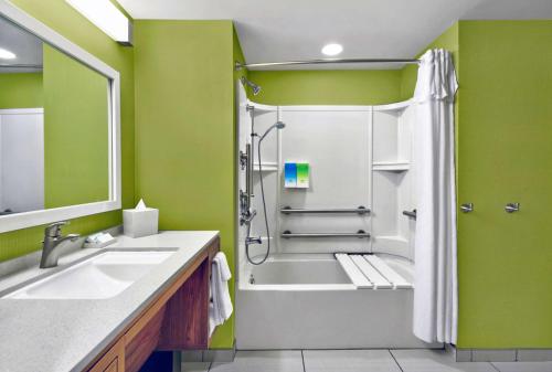 a bathroom with a shower and a tub and a sink at Home2 Suites by Hilton Rochester Henrietta, NY in Rochester