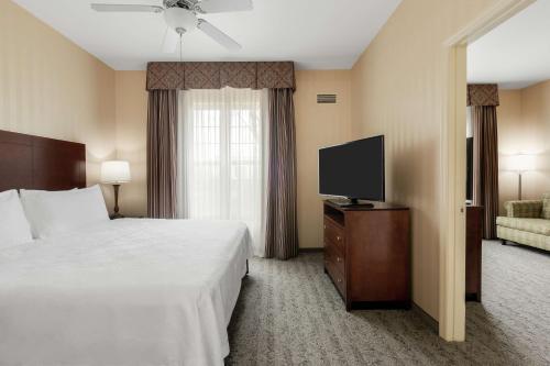a hotel room with a bed and a flat screen tv at Homewood Suites by Hilton Sacramento Airport-Natomas in Sacramento