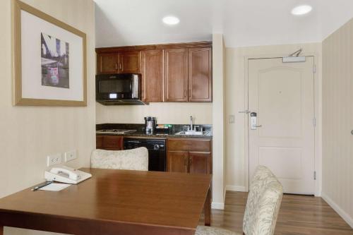 a kitchen with a wooden table with chairs and a counter top at Homewood Suites by Hilton Sacramento Airport-Natomas in Sacramento