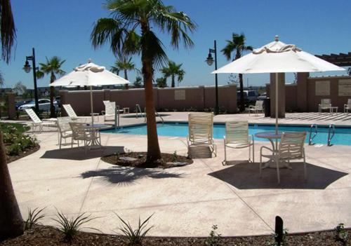 un patio con sillas y sombrillas junto a una piscina en Hampton Inn & Suites Sacramento-Airport-Natomas, en Sacramento