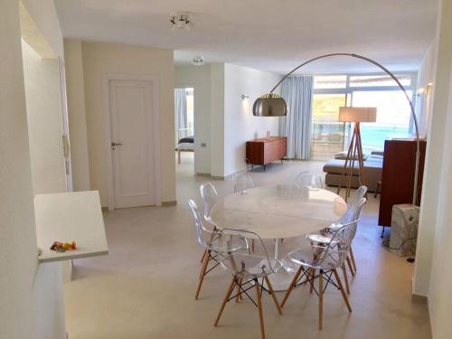 einen Esstisch und Stühle im Wohnzimmer in der Unterkunft Grand appartement de standing avec vue sur mer à Medano, Tenerife sud in La Tejita