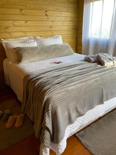 a large bed in a bedroom with a window at Chalé Vale das Pedras in Praia Grande