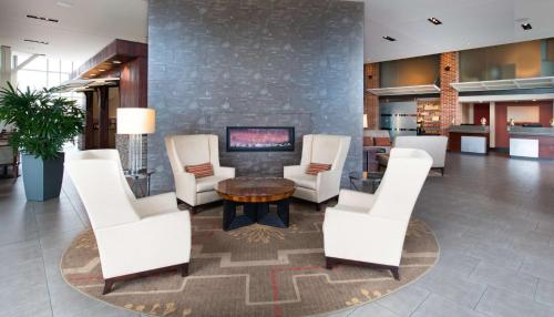 a lobby with white chairs and a table and a fireplace at DoubleTree Hotel & Suites Charleston Airport in Charleston