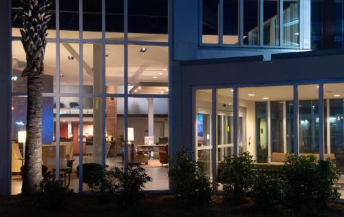 a blue building with a palm tree in front of it at DoubleTree Hotel & Suites Charleston Airport in Charleston