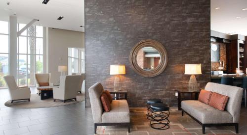 a lobby with chairs and a mirror on a wall at DoubleTree Hotel & Suites Charleston Airport in Charleston