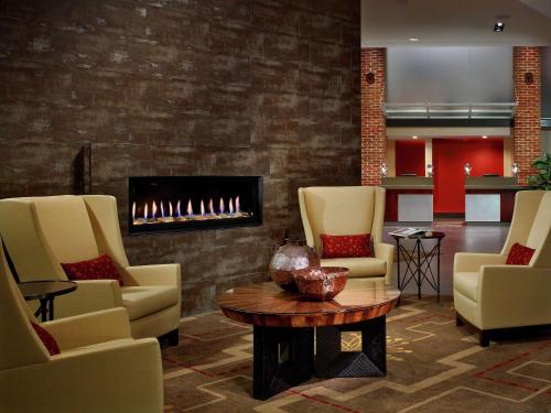 a lobby with chairs and a fire place at DoubleTree Hotel & Suites Charleston Airport in Charleston