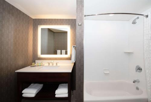 DoubleTree Hotel & Suites Charleston Airport في تشارلستون: حمام مع حوض وحوض استحمام ودش
