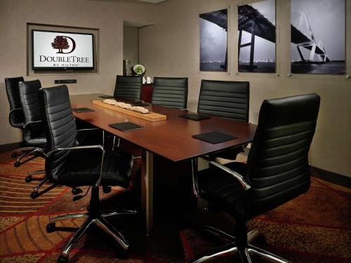 a conference room with a wooden table and black chairs at DoubleTree Hotel & Suites Charleston Airport in Charleston