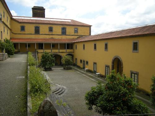 a large yellow building with a courtyard in front at Casa do Mosteiro de Refoios do Lima in Ponte de Lima