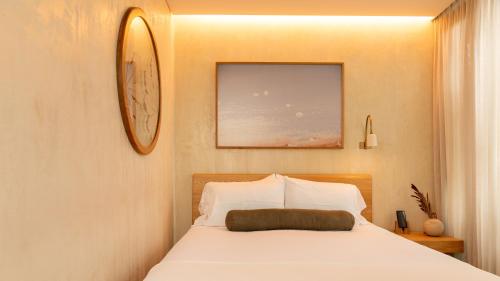 a bedroom with a bed with a clock on the wall at 23 Hotel Medellin in Medellín