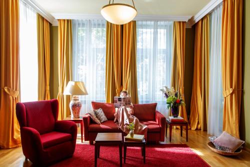 a living room with red chairs and a red rug at Louisa's Place in Berlin