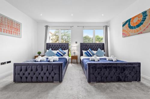 2 Betten in einem Zimmer mit 2 Fenstern in der Unterkunft Bermondsey Guest House in London