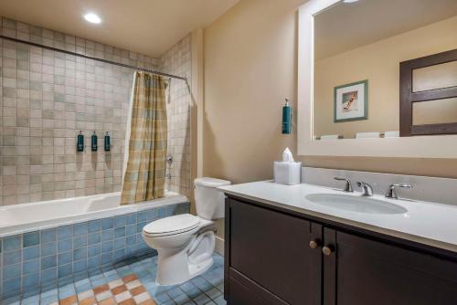 a bathroom with a toilet and a sink and a mirror at Hilton Grand Vacations Club Blue Mountain Canada in Blue Mountains