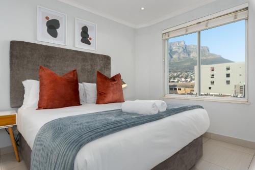 a bedroom with a large bed with a large window at 220 On Loop Luxury Apartments in Cape Town