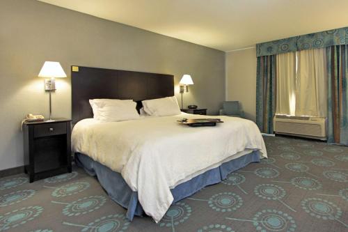 a hotel room with a large bed and a window at Hampton Inn Defiance in Defiance