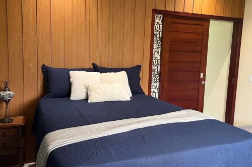 a blue bed with two pillows on top of it at Casa Retrô Chique Bananeiras - Cond Yes Banana in Bananeiras