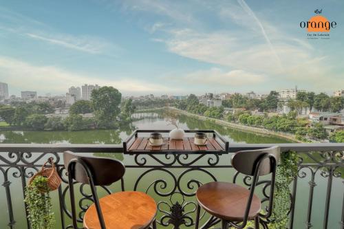 a balcony with chairs and a view of a river at iRest Orange Tay Ho Lakeside Apartment in Hanoi