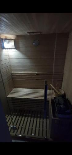 a room with a bed in a room with a clock at Hedonic Wellness Apartmani in Niš