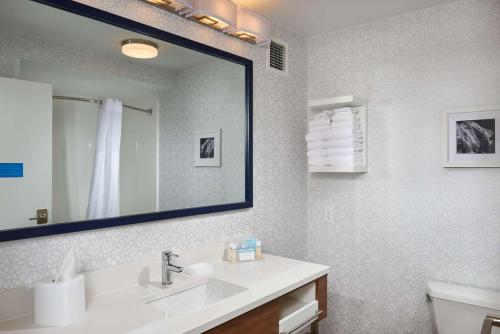 a bathroom with a sink and a mirror at Hampton Inn Butte in Butte